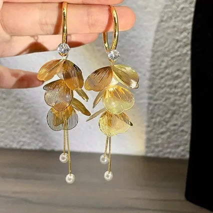 Gold floral petal pearl fringe drop earrings with electroplated alloy finish on neutral background