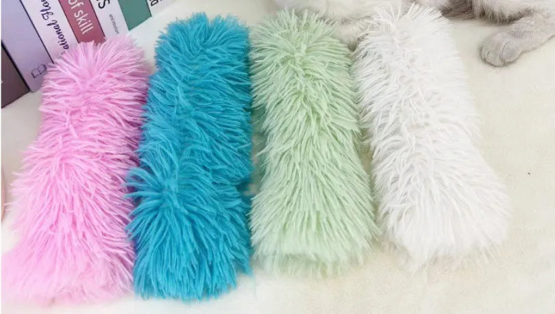 Green, white, blue, and pink plush cat toy pillow measuring 27 by 10 centimetres.