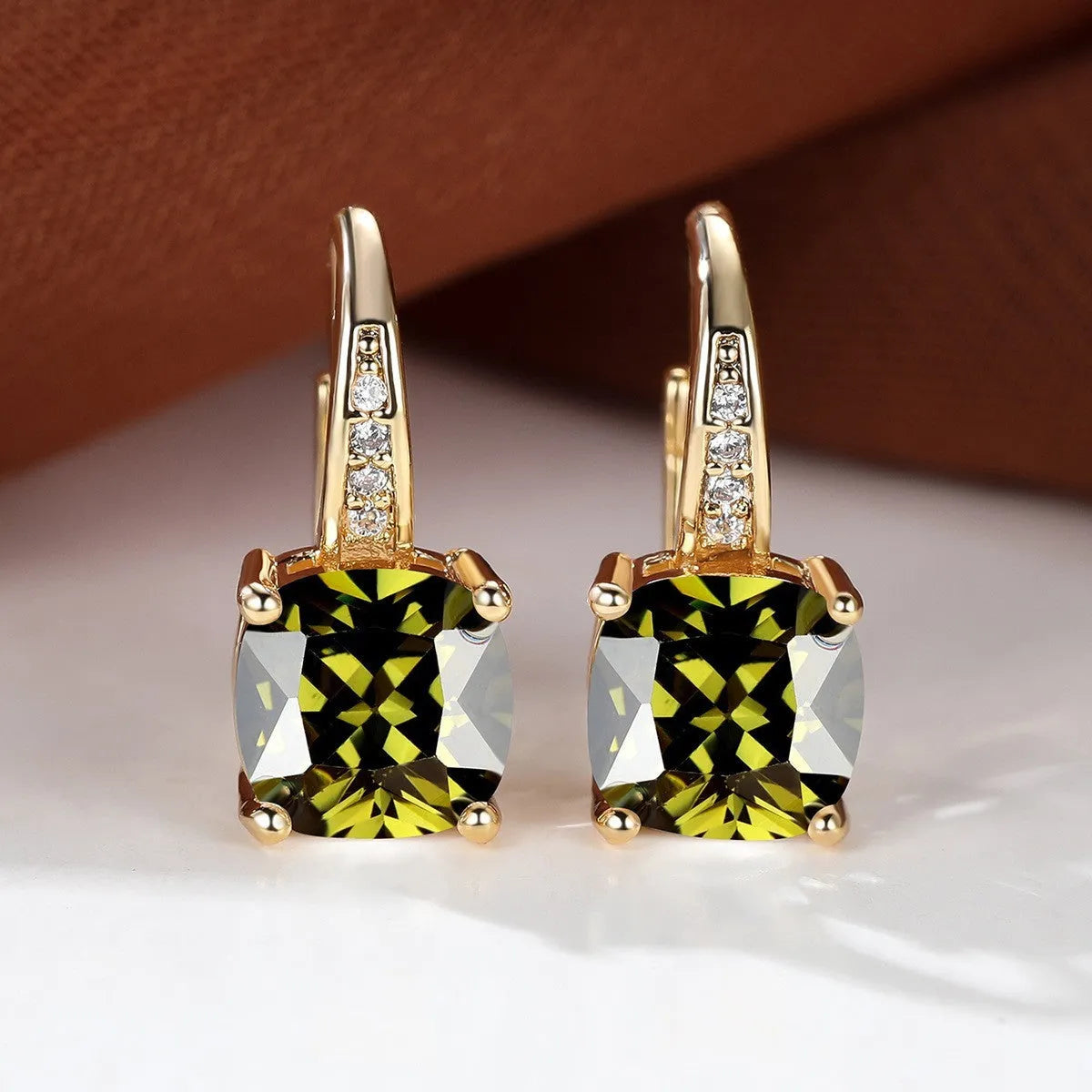 Square geometric ear hook studs with a round zircon stone, shown in a gold electroplated finish.