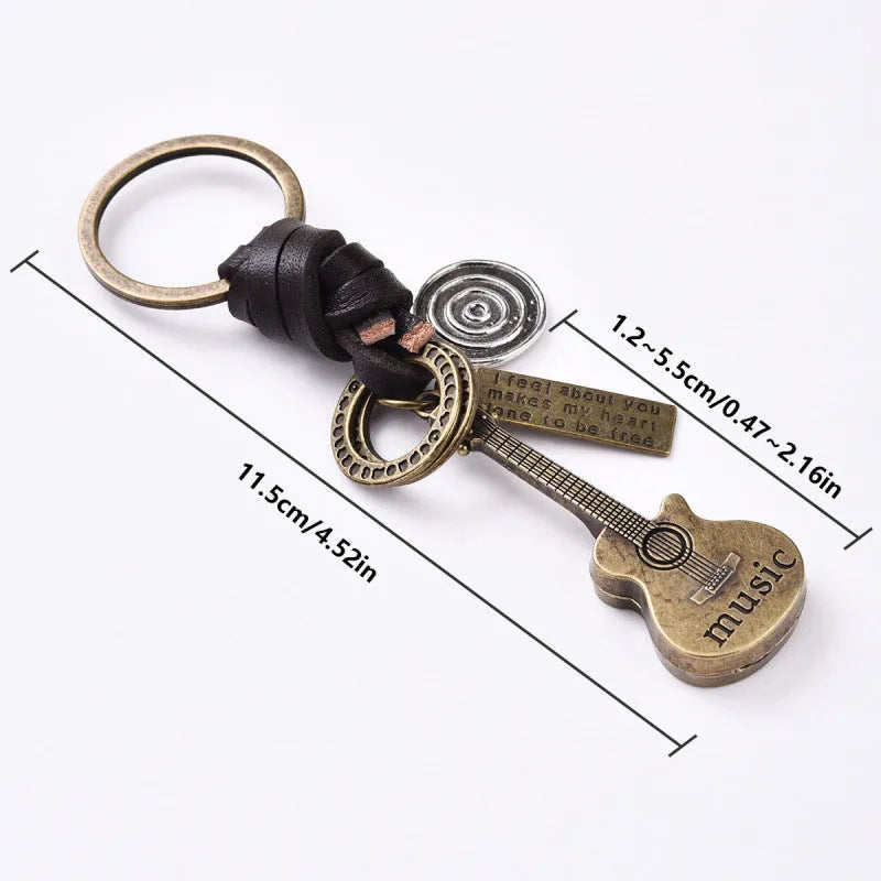 Retro guitar keychain pendant with woven cowhide charm and electroplated alloy finish on white background