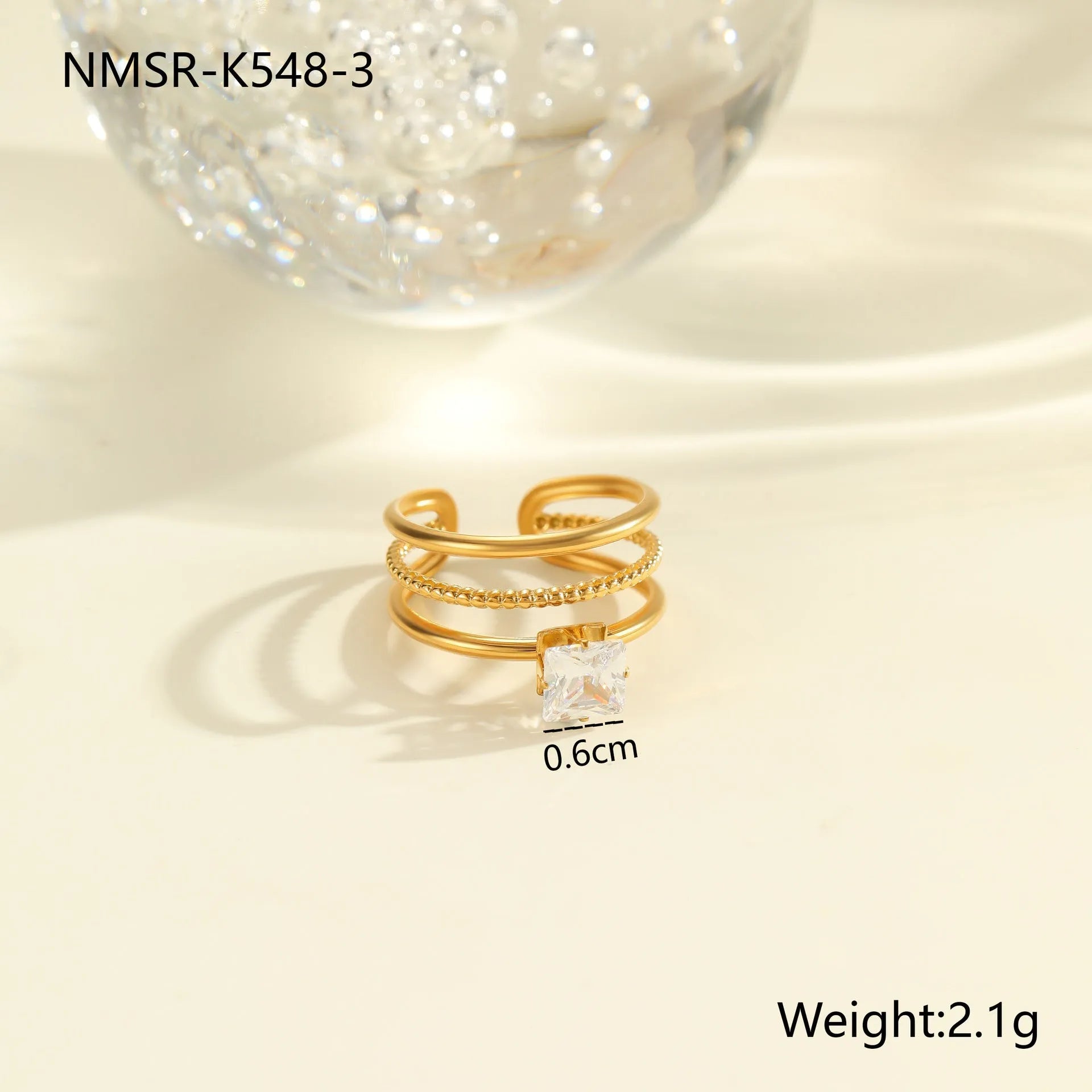 Gold-coloured adjustable stainless steel ring with zircon geometric shapes on white background.