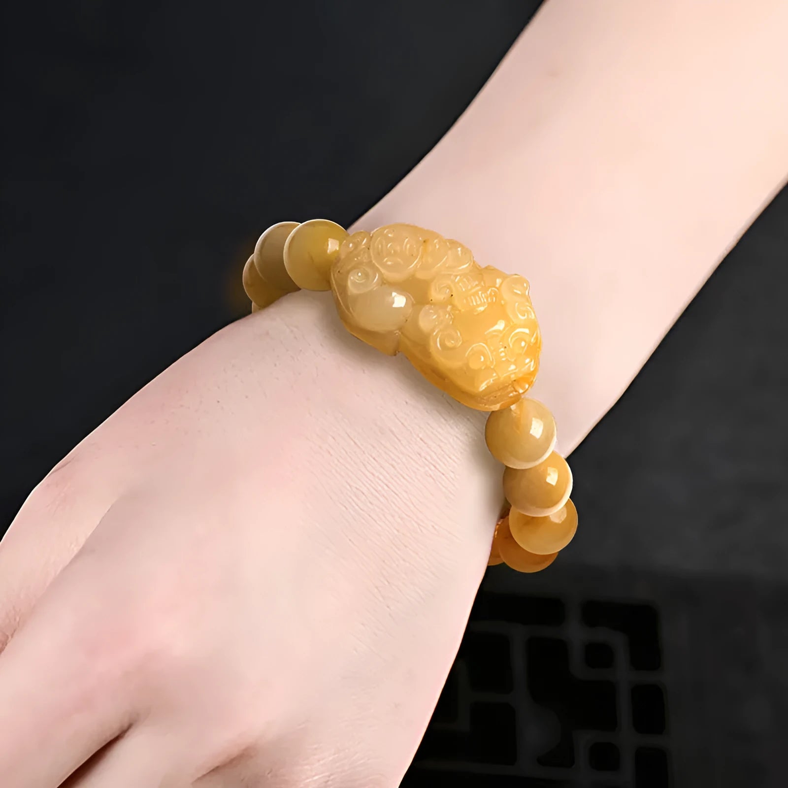 Carved Jinsi Jade money bracelet with Chinese characters on leather cord in gold thread colour