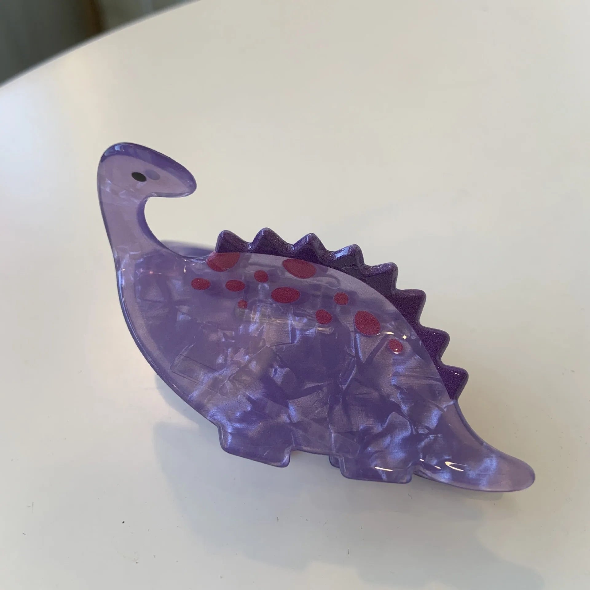 Dinosaur-themed acrylic jaw hair clip showing grip design with miniature dinosaur decoration