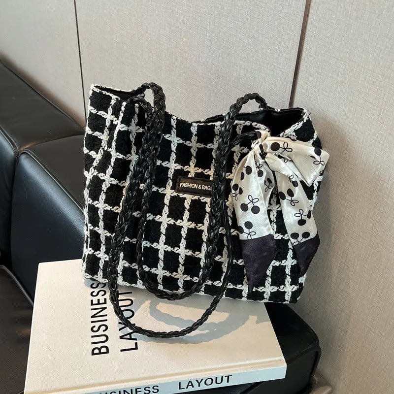 Black woven wool shoulder bag with horizontal square design showing internal organisation pockets and exterior sandwich compartment