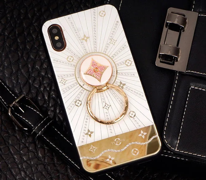 Luxury diamond and gold ring holder stand holding an iPhone for hands-free viewing.