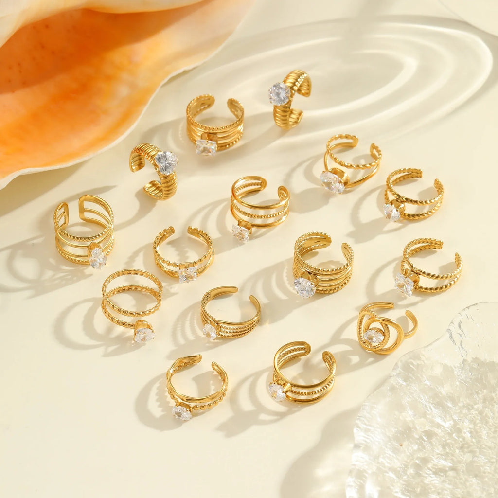 Gold-coloured adjustable stainless steel ring with zircon geometric shapes on white background.