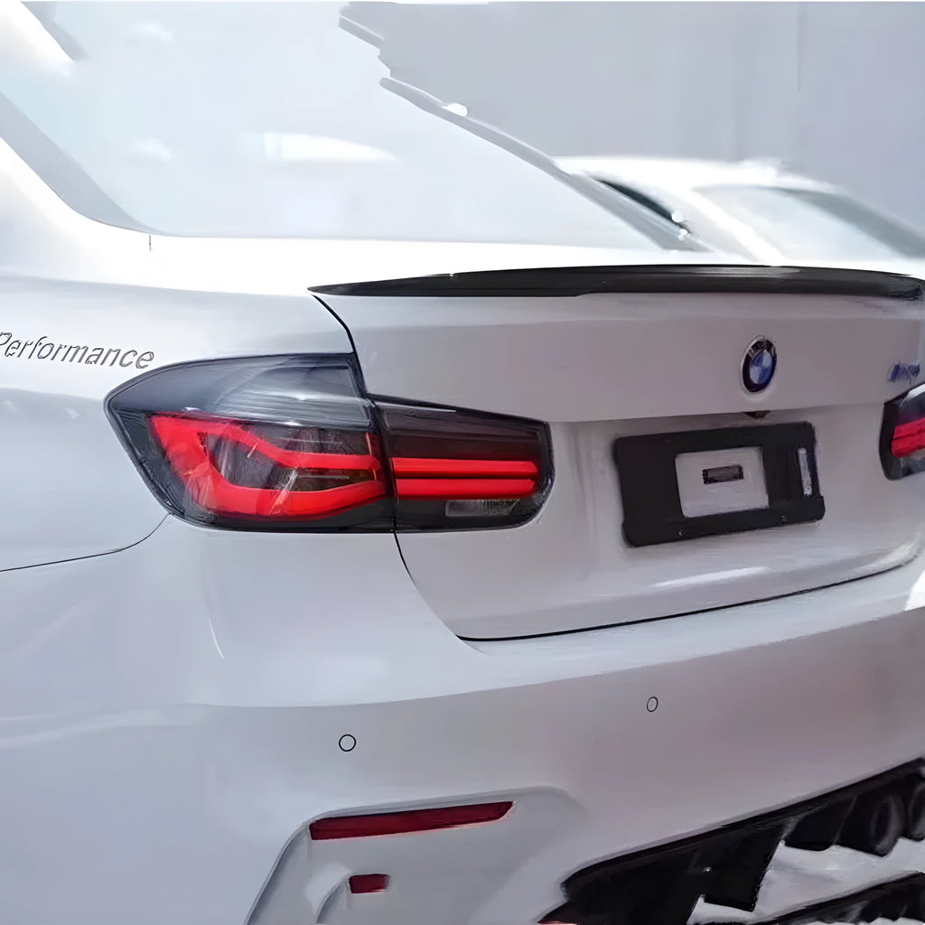 BMW 3 Series modified LED tail light assembly in smoked black finish, showing streamer light pattern.
