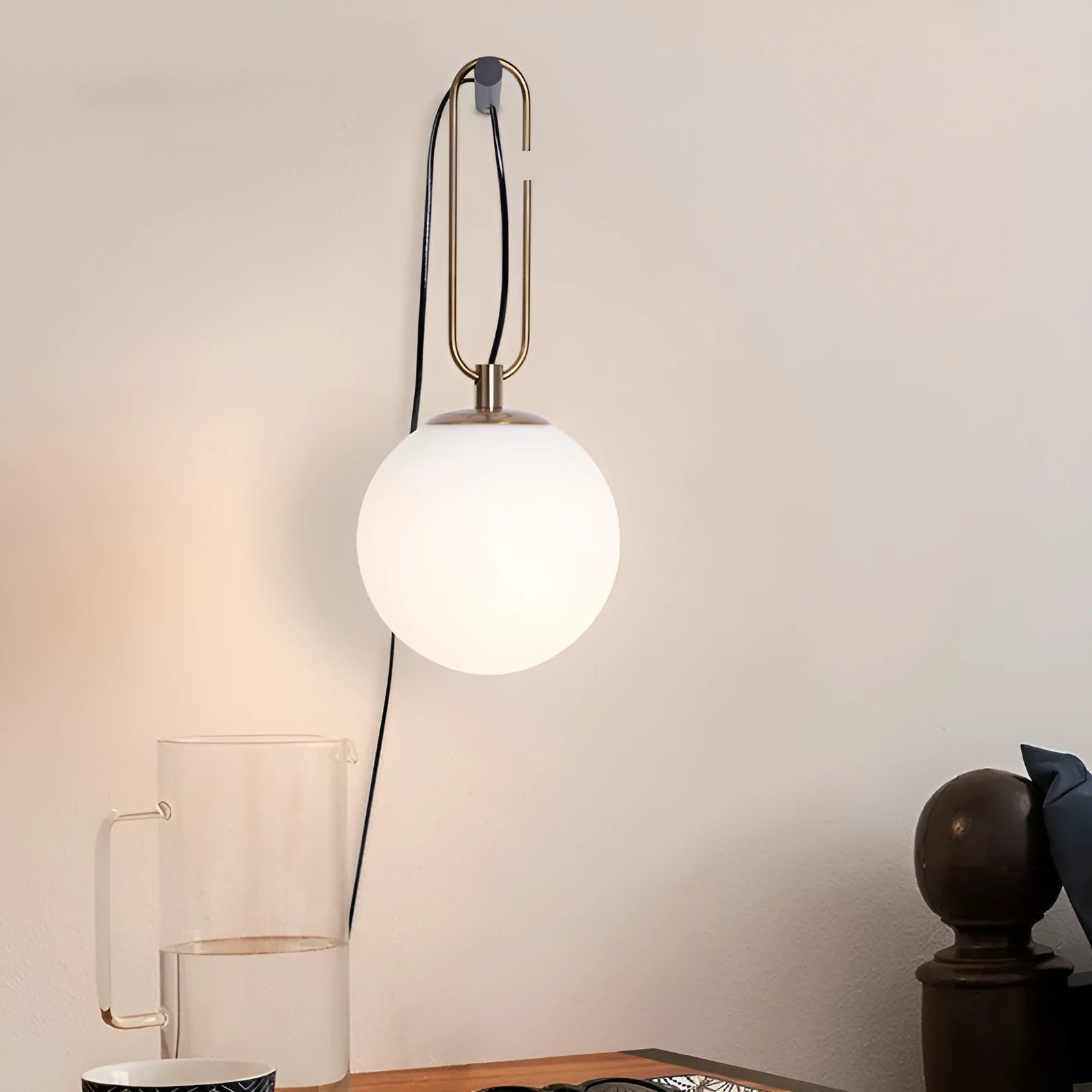 Contemporary clear glass wall light fixture with modern design on a white wall.
