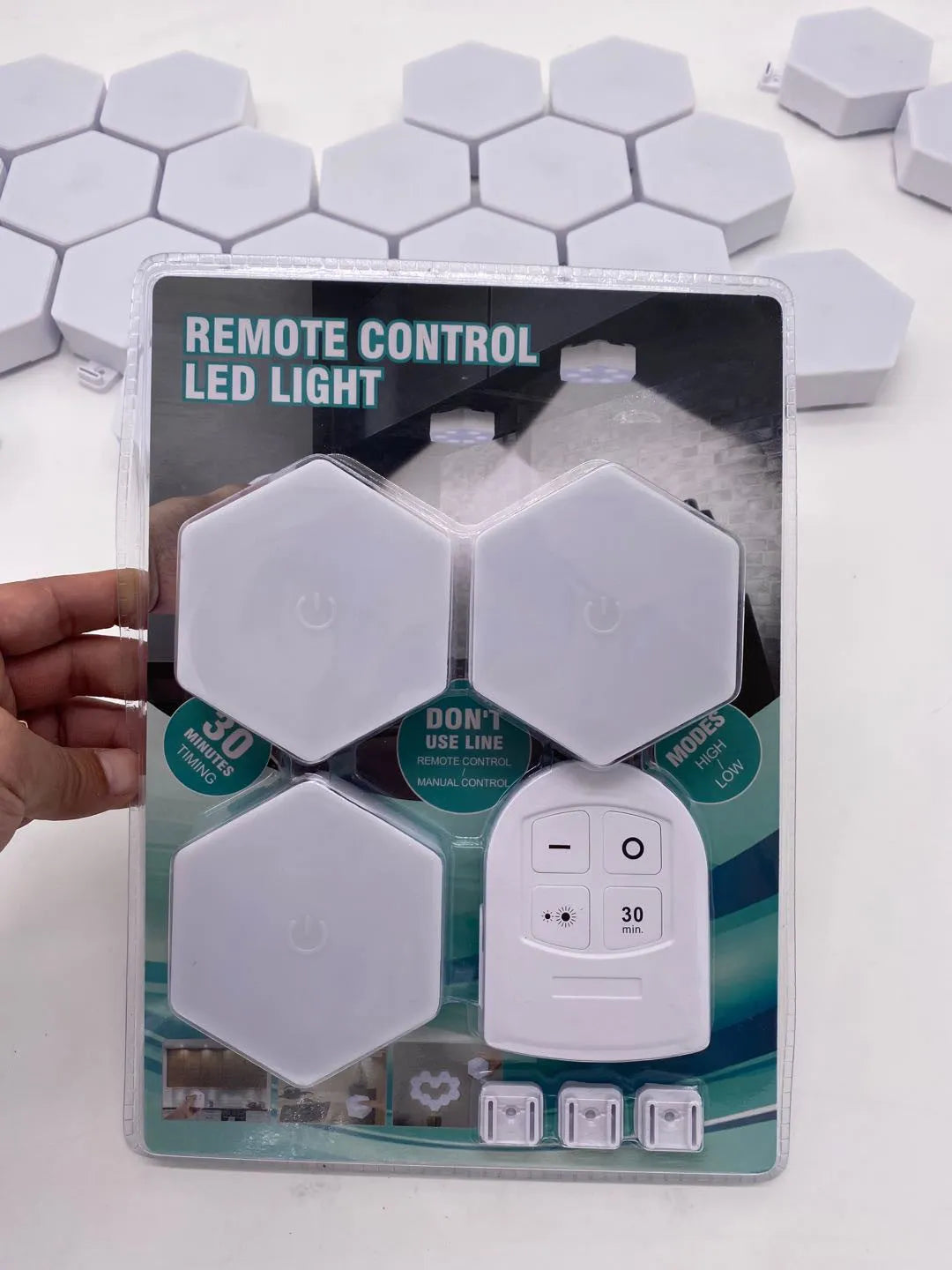 White wireless remote control LED pat light with touch sensor and compact rectangular design.
