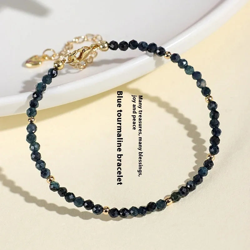 Close-up of a women's blue tourmaline beaded bracelet with 3mm gemstone beads and spacer details.
