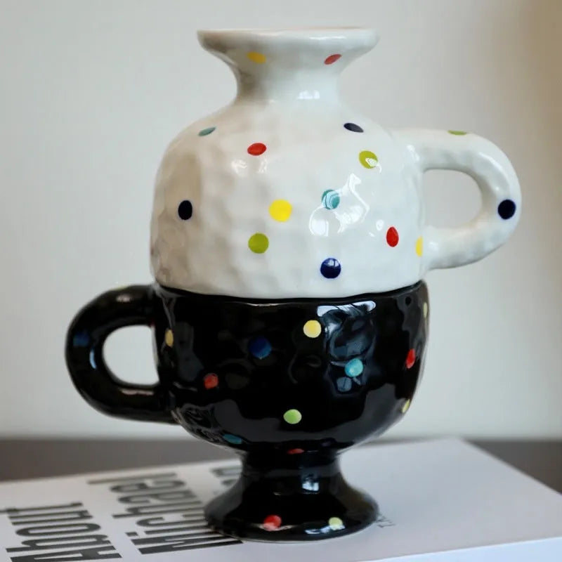 Hand-pinched irregularly shaped ceramic mug in a solid colour, shown on a table.