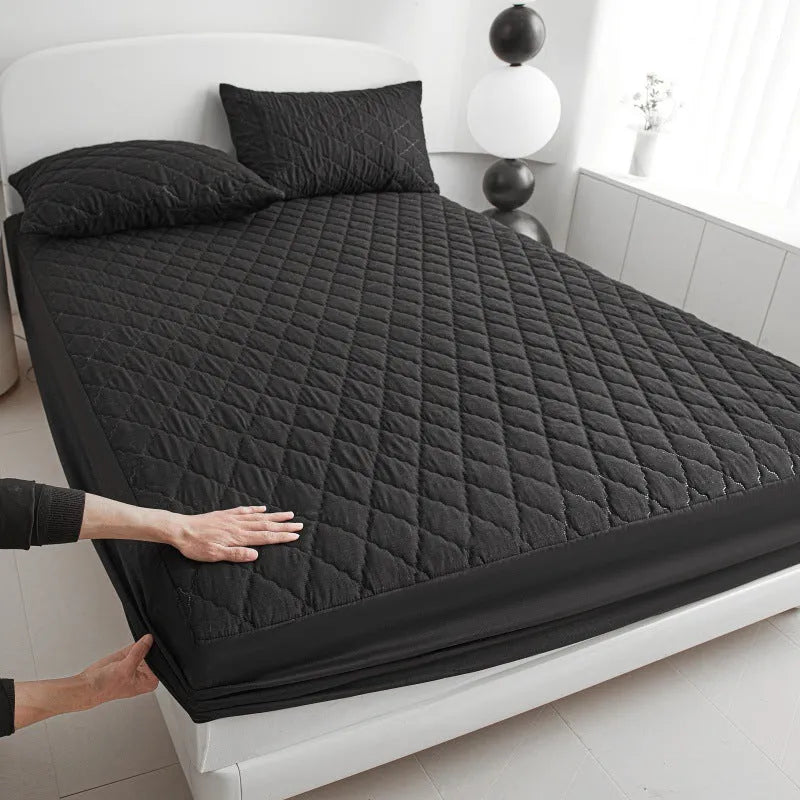 Diamond lattice quilted waterproof mattress protector and pillowcases in a solid colour.