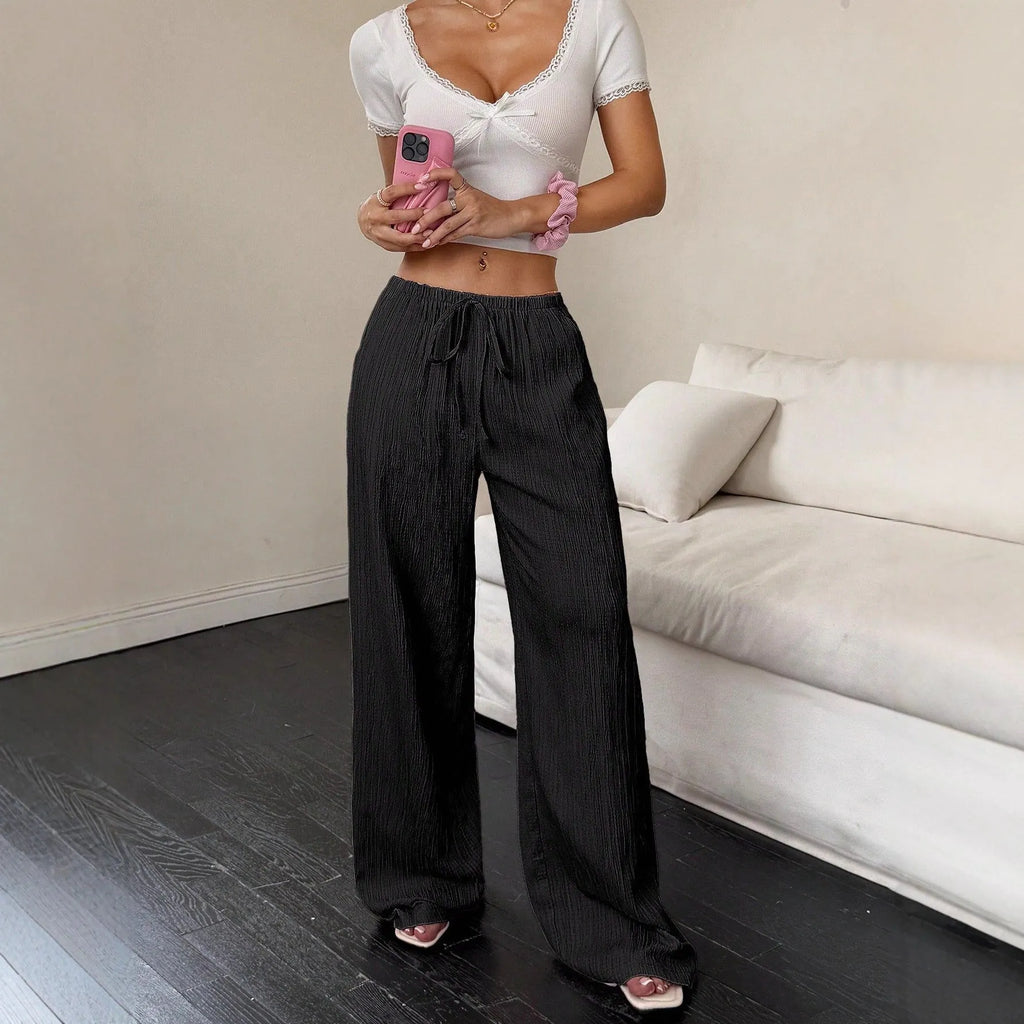 Women's black wide-leg trousers with lace-up waist trimming detail on mid-rise waist