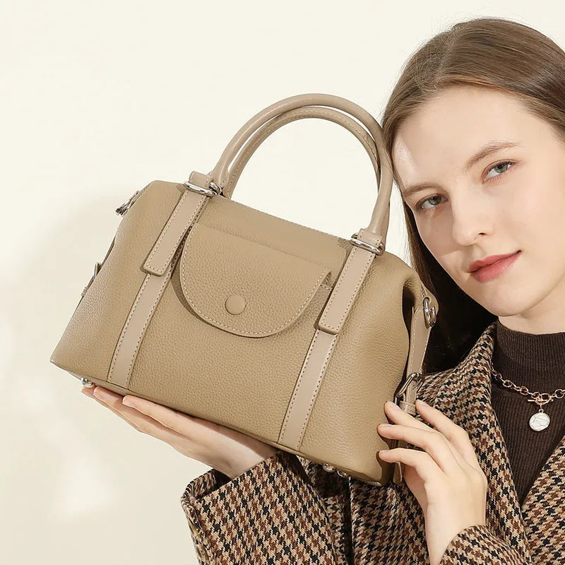 Genuine leather ladies handbag in street trend style with contrast stitching and lock detail.