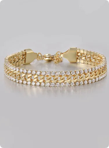 Gold coloured hip hop style tennis bracelet with stone inlay on a wrist.