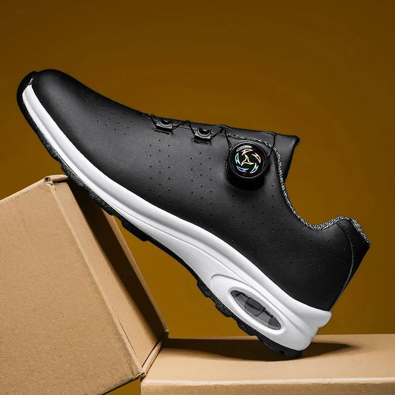 Low-top black and white tennis shoes with mesh uppers, cross shoulder straps, and a flat composite sole.