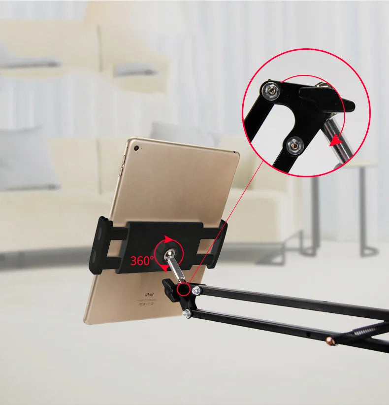 Black adjustable phone and tablet stand holding a mobile device on a desk.
