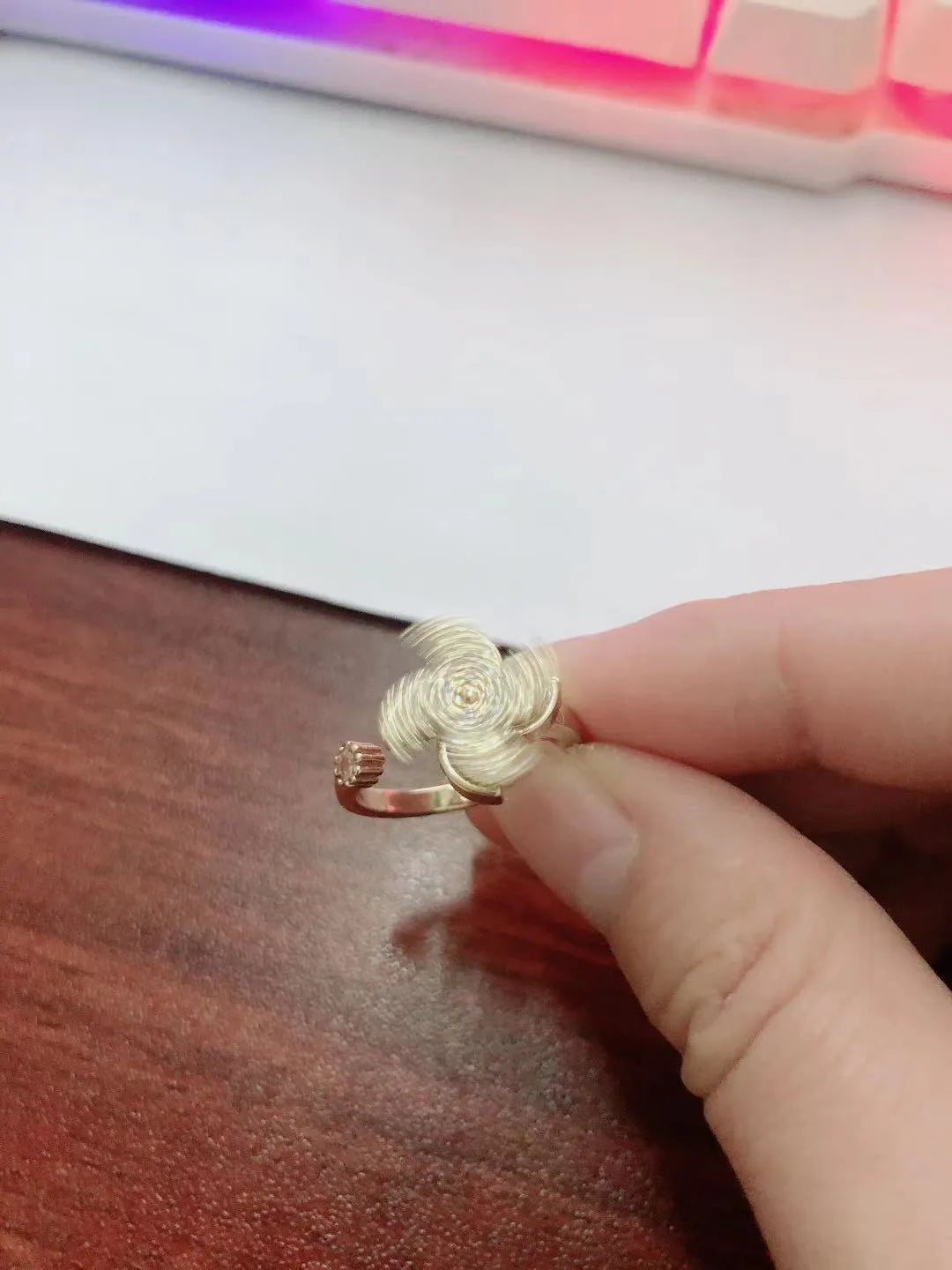 Geometric windmill rotating ring in gold electroplated finish showing circular design with movement elements