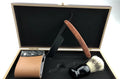 Shaving kit gift set with double edge safety razor, shaving brush, stand, soap cup, and travel pouch on a wooden surface.