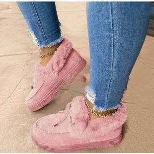 Womens white cotton slip-on shoes with round toe and non-slip rubber sole on a wooden floor.