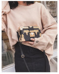 Women's hard PU shoulder bag with flap closure and crossbody strap in black colour with rivet decoration
