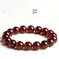 Natural orange red garnet ball bracelet in retro unisex style on wrist, showing crystal links and ruyi design details.