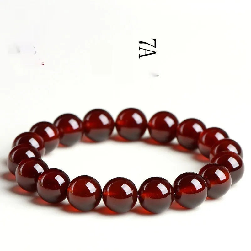 Natural orange red garnet ball bracelet in retro unisex style on wrist, showing crystal links and ruyi design details.