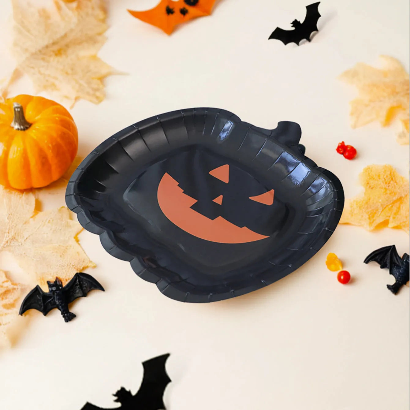 Black disposable paper plate with cute pumpkin design for Halloween, 9 inches in diameter.
