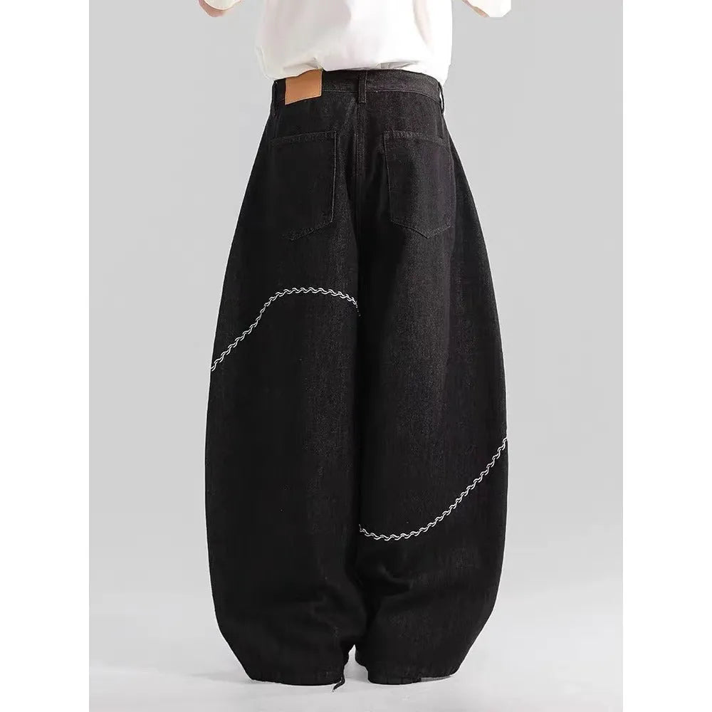 Black straight-leg denim trousers with a mid-waist and zip fly, laid flat.
