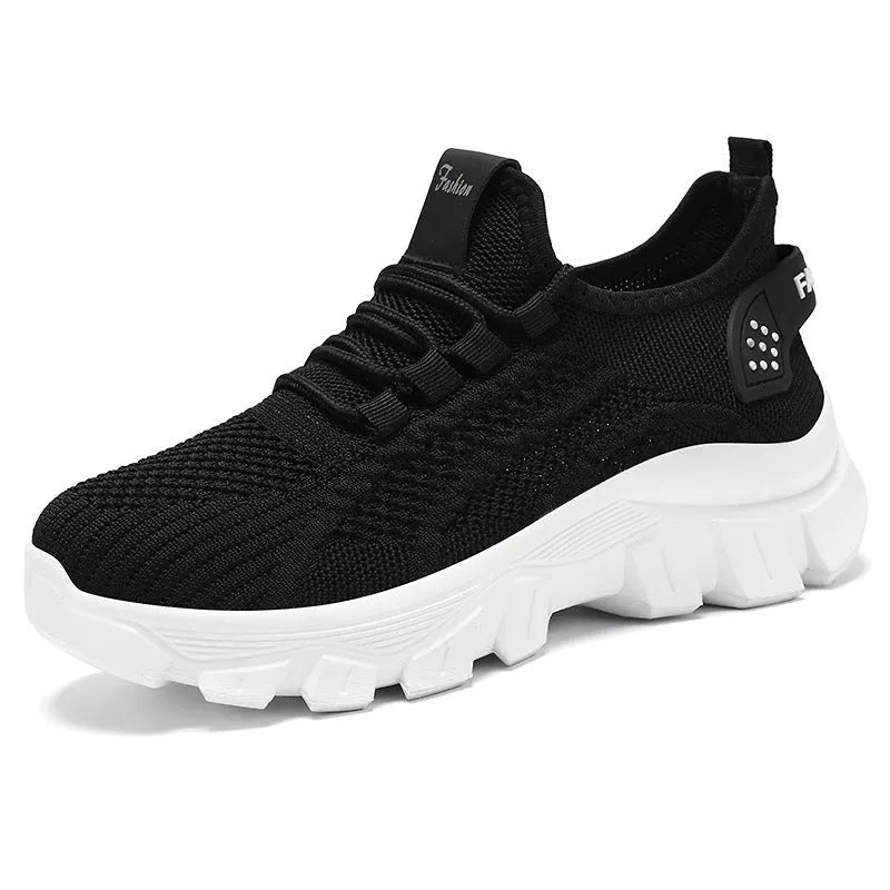 Women's white Flyknit running sneakers with round toe, flat heel, and thick PVC sole on a light background.