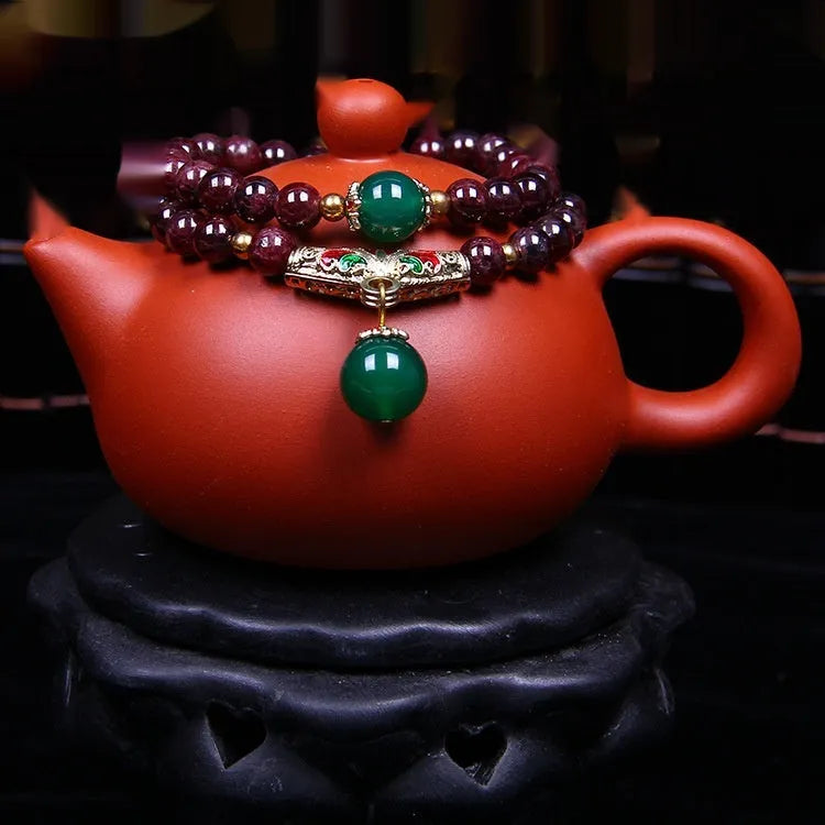 Natural garnet bracelet with 7mm beads and golden toad design on wrist