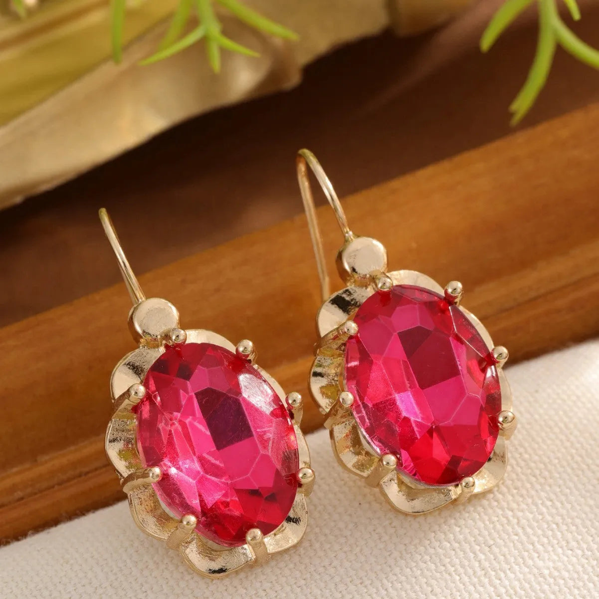 Pair of diamond studded earrings in polished zinc alloy, available in light blue, rose red, and royal blue colours
