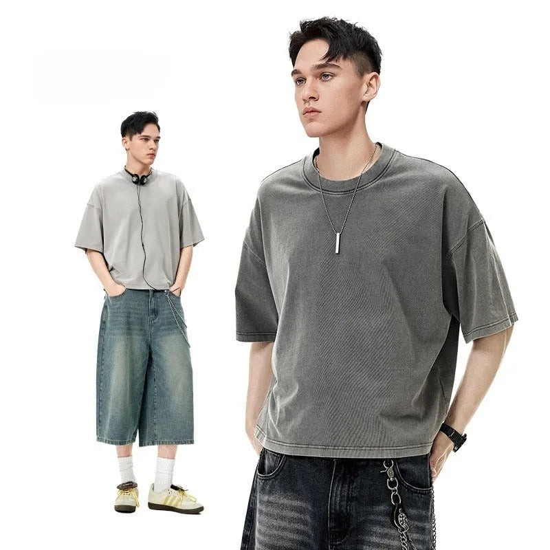 Men's vintage-style light khaki cotton t-shirt with a loose fit and drop-shoulder sleeves on a hanger.