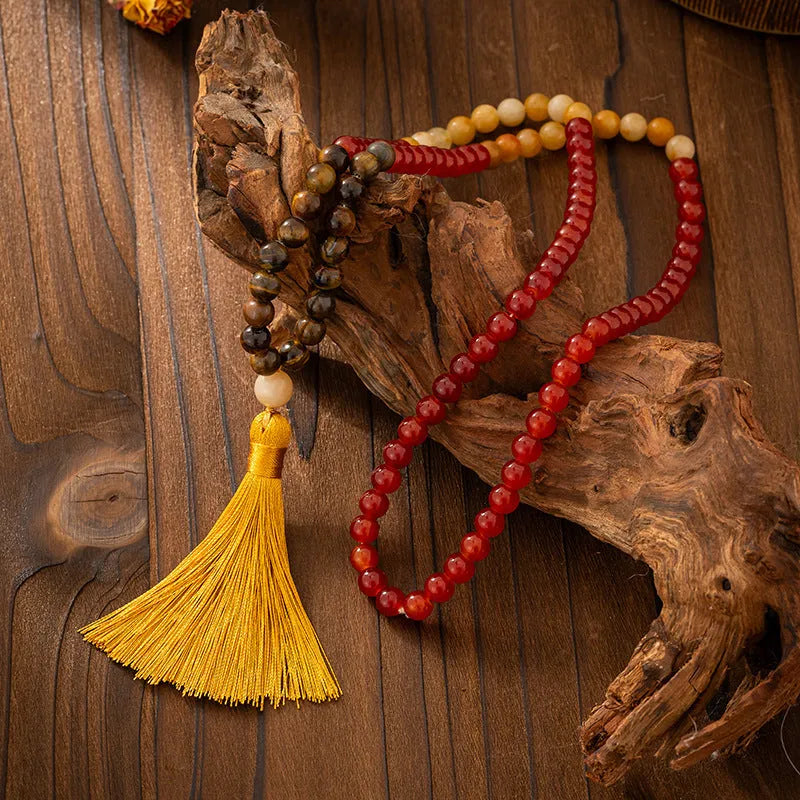 Vintage bohemian long necklace with geometric stone beads and tassel, shown with a matching shorter bracelet.
