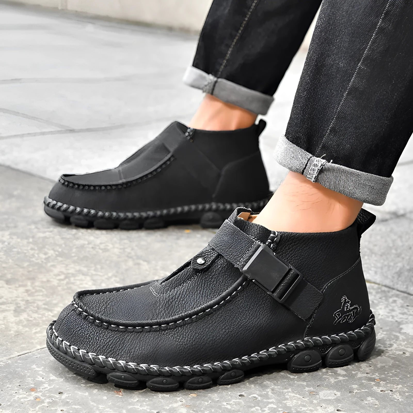 Men's black casual slip-on shoes with handmade stitching on the synthetic leather upper and a flat sole.