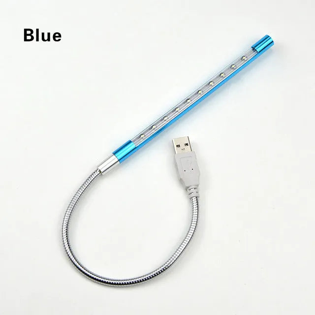Black aluminium alloy spiral USB LED night light on a desk next to a laptop
