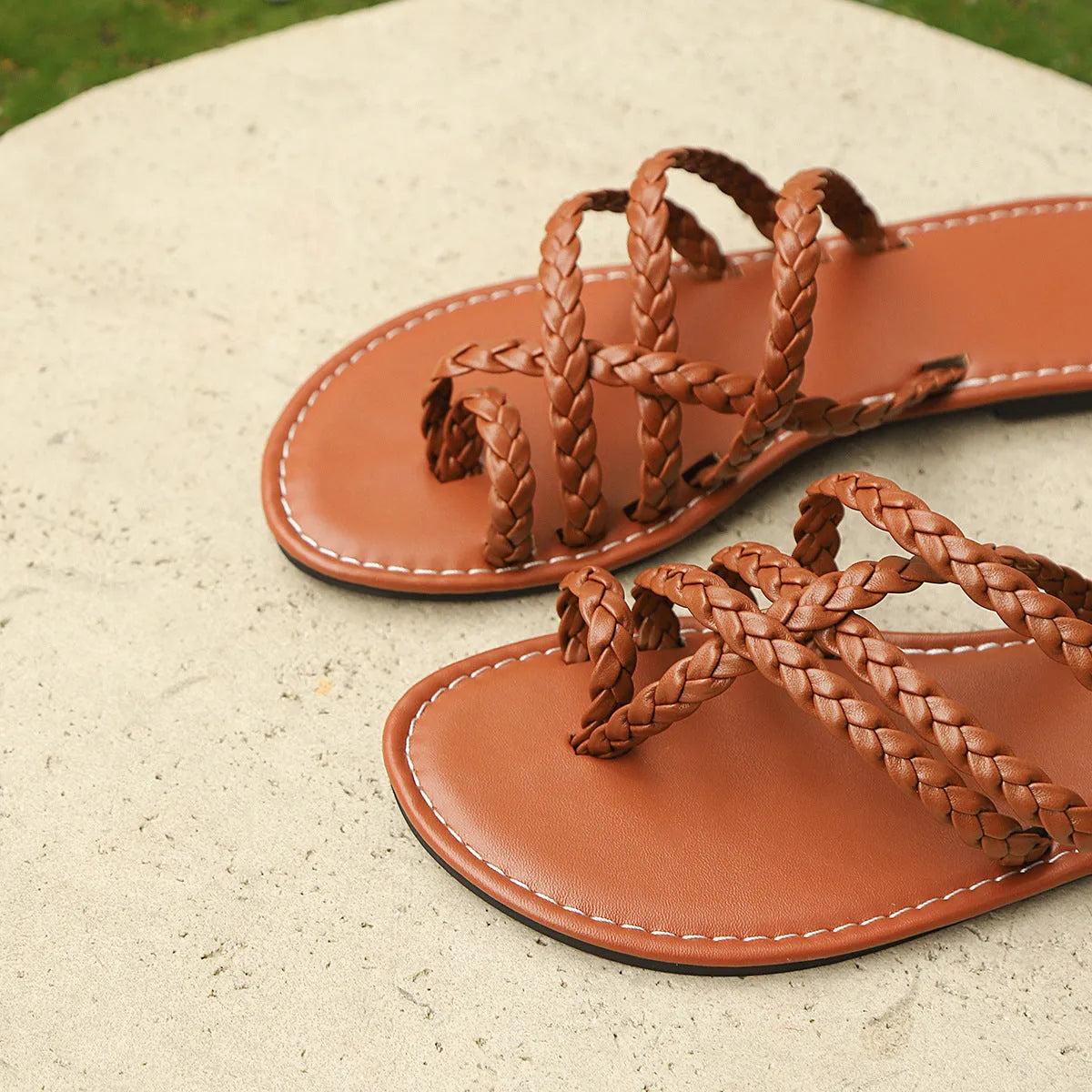 Women's brown woven clip-toe flat sandals on a white background