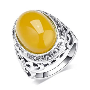 Geometric retro alloy ring in antique silver amber colour on a plain background.