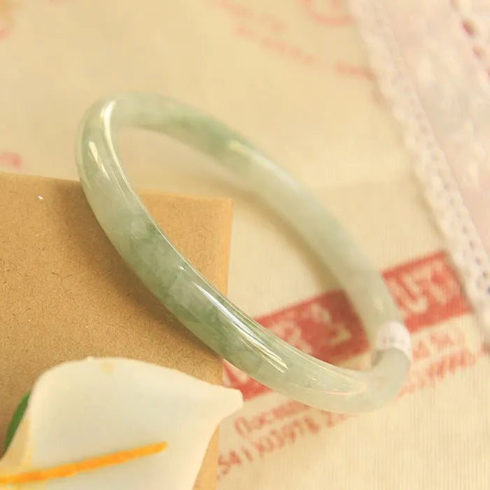 Green jade waxy geometric Chinese style bracelet showing 10mm width on wrist.