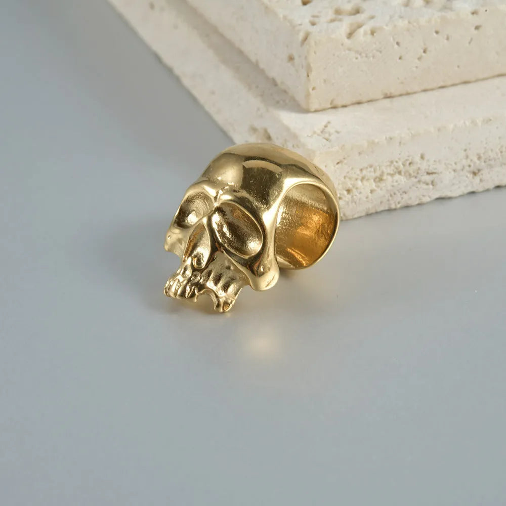 Stainless steel hollow skull Buddha earrings showing four colour finishes on geometry design