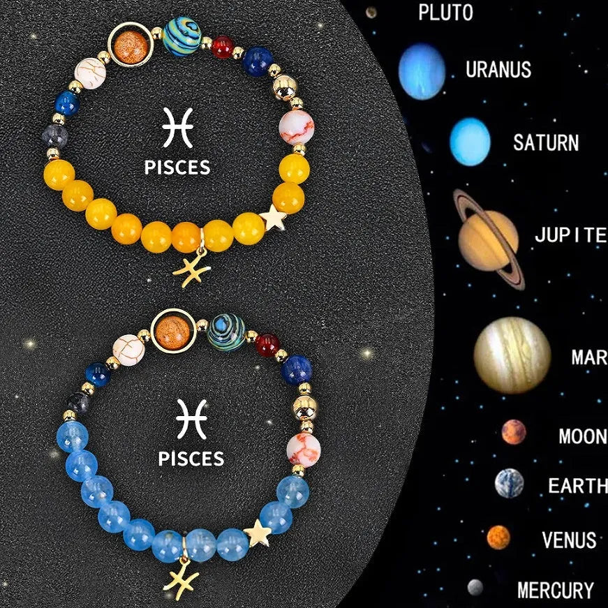 Two natural stone beaded bracelets with zodiac sign charms on a wooden surface