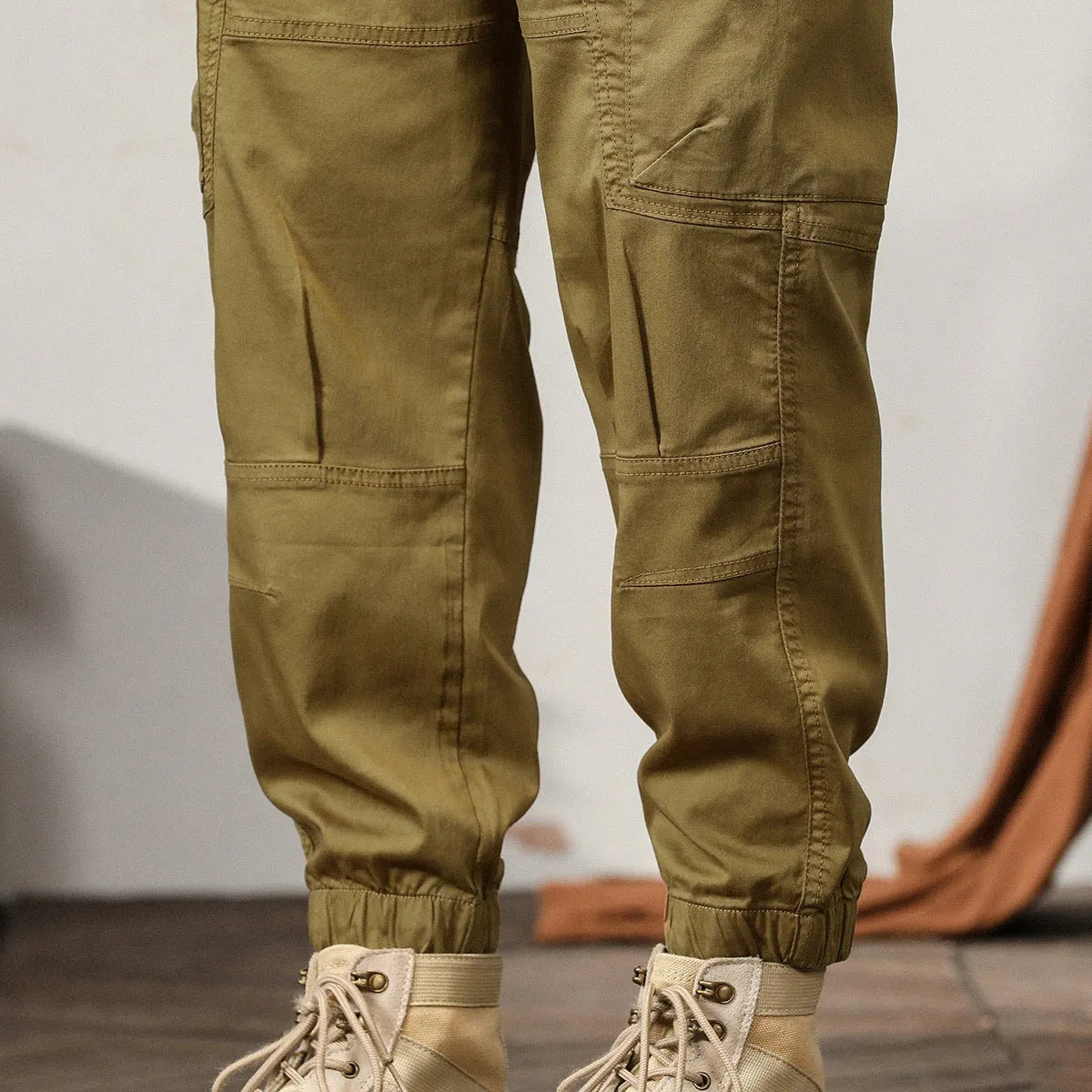 Men's loose fit cotton trousers with tapered ankle banded legs in khaki colour.
