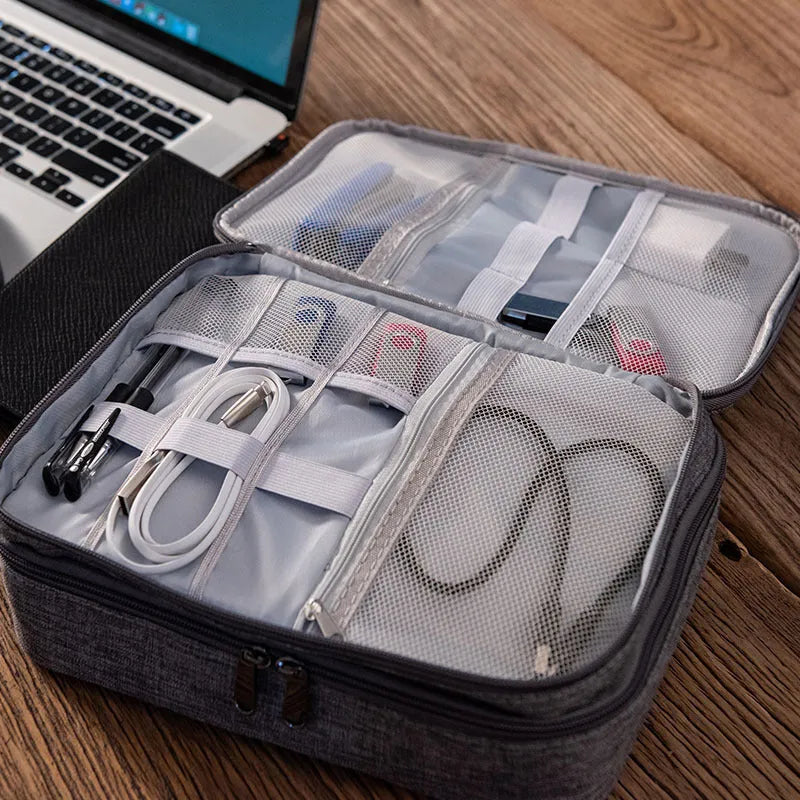 Grey waterproof electronics organiser with double-layer interior, adjustable dividers, and carrying handle