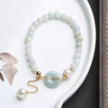 Natural emerald peace buckle pearl bracelet for women with jade round pendant on a geometric design.