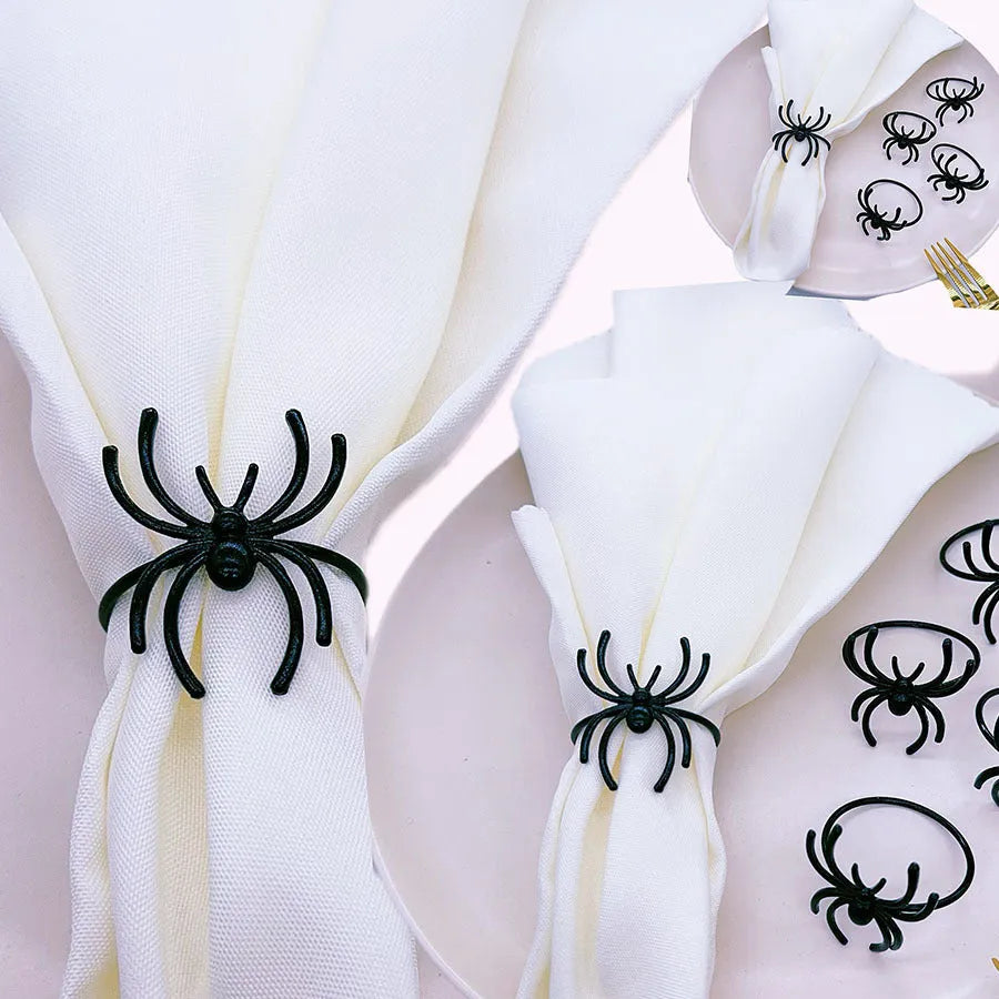 Six black metal spider-shaped napkin rings for Halloween table decoration.