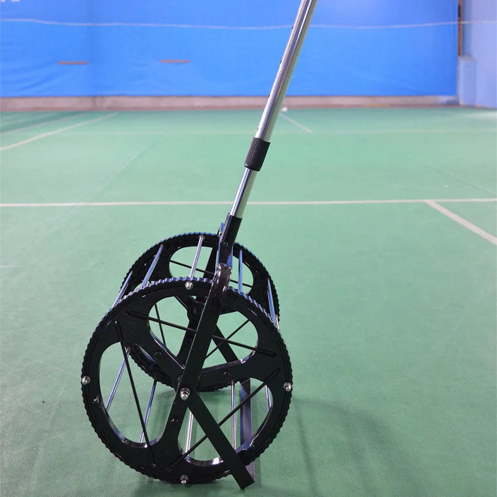 Black tennis ball picker basket made of nylon and metal on a court surface