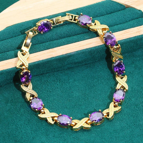 Gold plated jewellery set with blue cubic zirconia stones, showing necklace, earrings, ring, and bracelet.