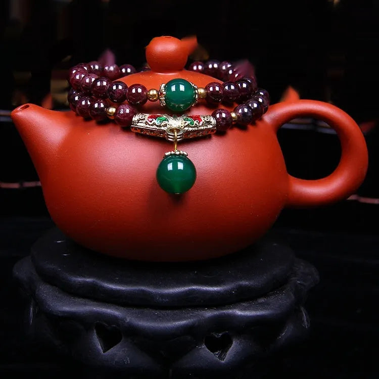 Natural garnet bracelet with 7mm beads and golden toad design on wrist