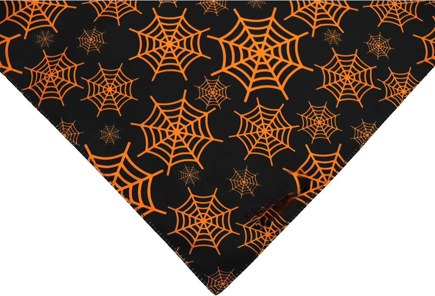 Reversible black and orange Halloween dog bandana with pumpkin and spider web patterns laid flat
