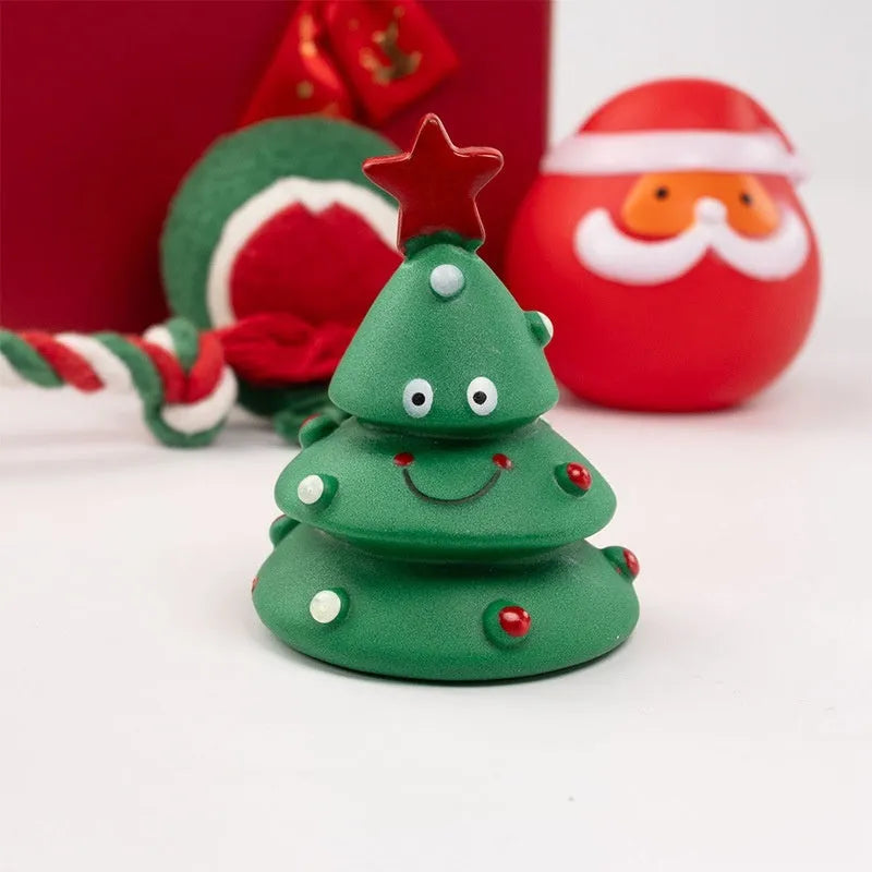 Christmas-themed vinyl dog toys including barbell, ball, rope, and Santa designs in gift packaging